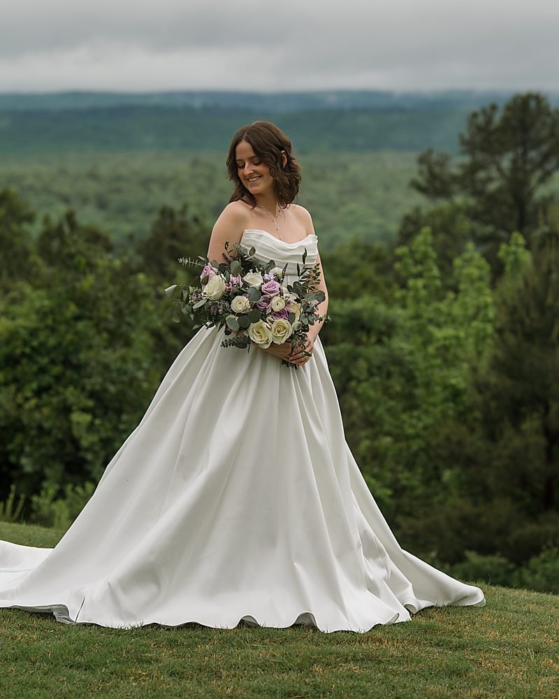 Bride overlooking the foggy tree-covered hills at a Central Arkansas wedding venue
