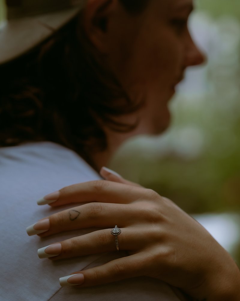 Engagement ring on her hand resting on his shoulder after an Arkansas proposal