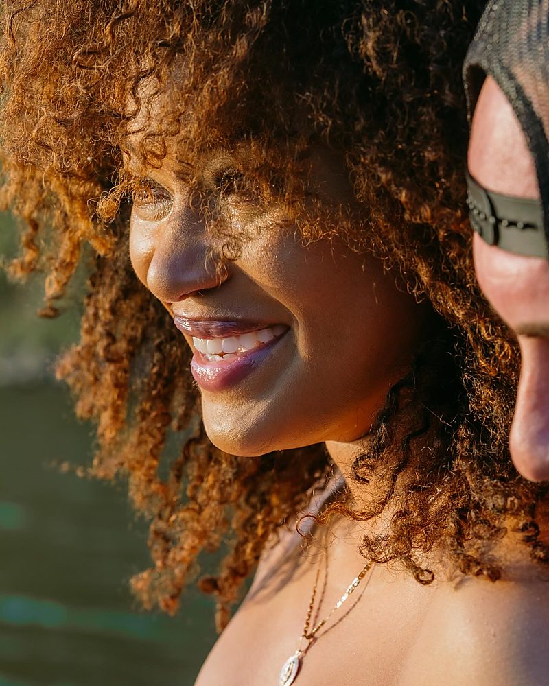 Engaged couple embracing at golden hour by the water in Central Arkansas