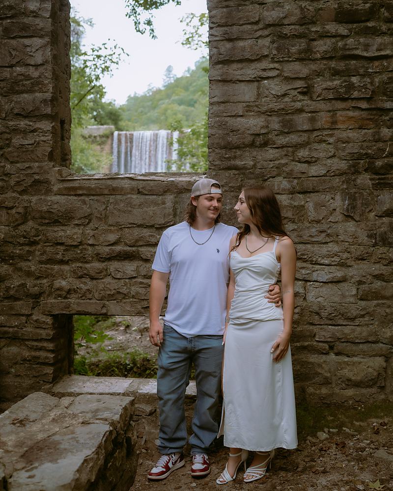 Newly engaged couple in the stone mill ruin overlooking Mirror Lake Falls in Arkansas