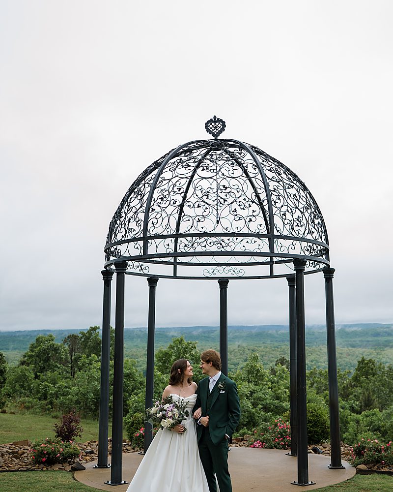 Couple beneath the iron gazebo at a hilltop Central Arkansas wedding venue
