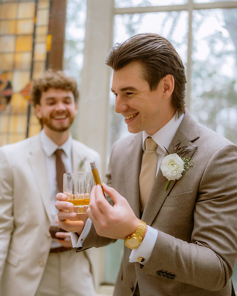 Groom and groomsman toasting while getting ready before a Central Arkansas wedding