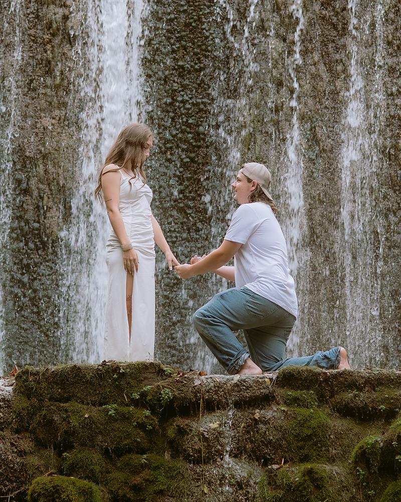 Surprise proposal on one knee at the base of Mirror Lake Falls in Arkansas