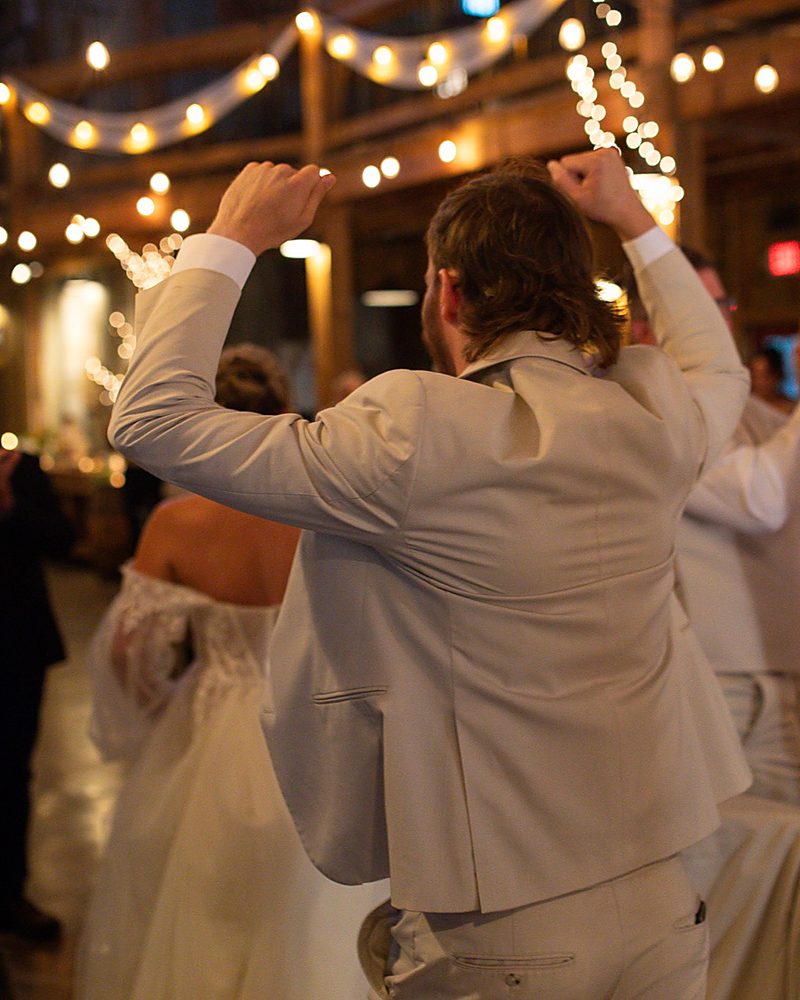 Newlyweds first dance under string lights at an Arkansas wedding reception