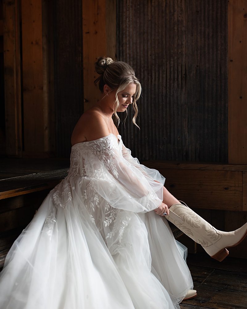 Bride in her gown and boots before a barn wedding in Arkadelphia Arkansas